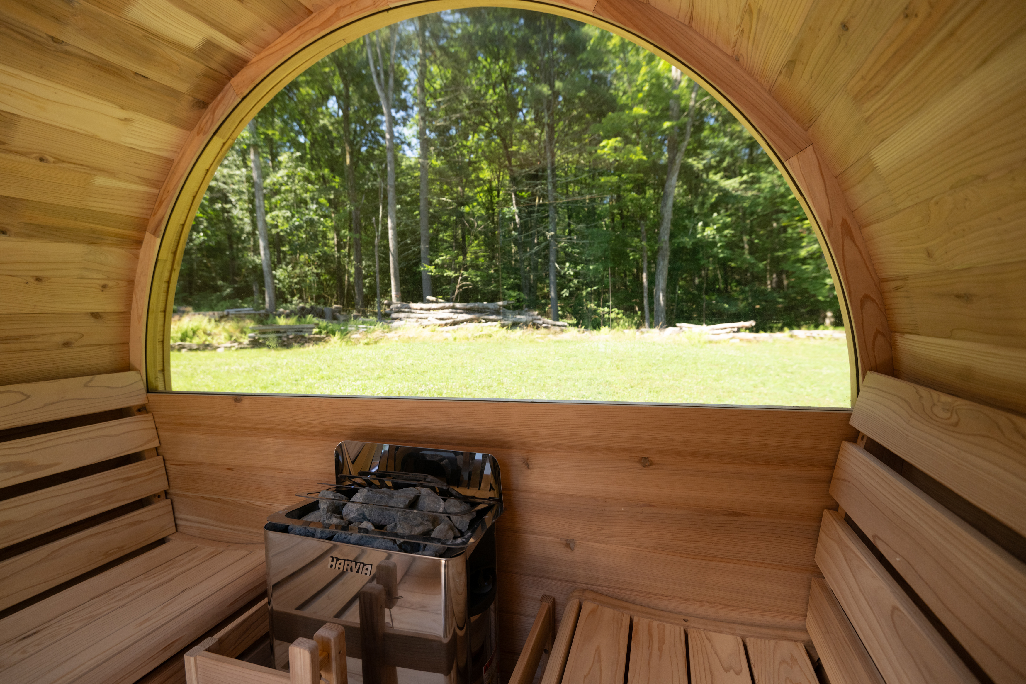 Inside the cedar barrel sauna with forest view